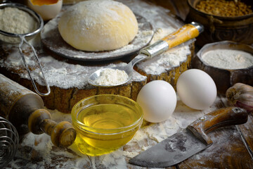 The process of kneading dough in the kitchen. Eggs, flour and other ingredients on the kitchen table in a composition.