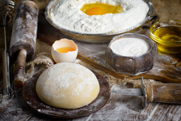 The process of kneading dough in the kitchen. Eggs, flour and other ingredients on the kitchen table in a composition.