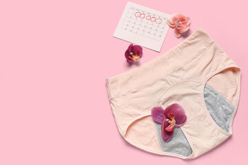 Composition with period panties, calendar and beautiful flowers on pink background