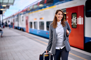 Young happy woman arriving at train station.