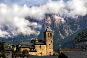 Vistas de la Iglesia de San Salvador en Torla-Ordesa y del  valle de Ordesa y Monte Perdido. - obrazy, fototapety, plakaty