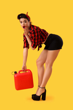 Shocked young pin-up woman with jerrycan on yellow background