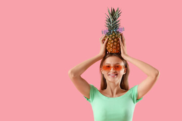 Pretty young woman with pineapple on pink background - obrazy, fototapety, plakaty