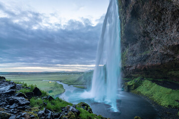 Masses of water from the Seljalandsfoss waterfall cascade down into a lake.