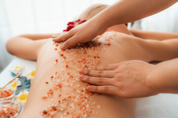 Closeup woman customer having exfoliation treatment in luxury spa salon with warmth candle light...