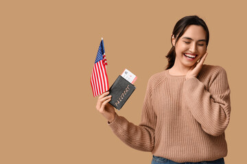 Pretty young woman with USA flag and passport on beige background. Immigration concept