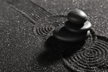 Stack of stones on dark sand with lines. Zen concept
