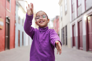 Smiling child in casual clothing enjoying the city architecture.