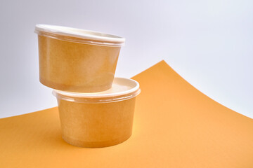 Kraft paper tableware: cups, food boxes, isolated on a light background. A set of various disposable tableware. Recycling and zero waste concept. Mock up
