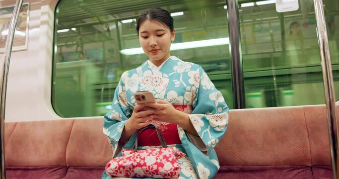 Japan woman, travel and train on smartphone, typing and metro transport on vacation on social media. Person, cellphone and traditional clothes on trip with technology and commute in town in kimono