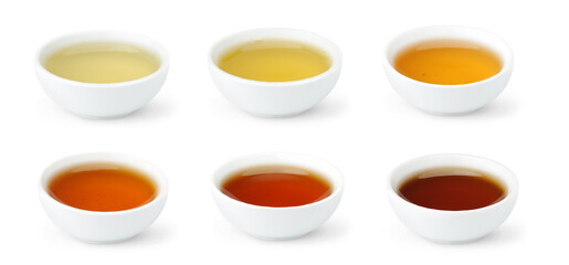 Brewed Chinese teas of different color in white bowls isolated on white background