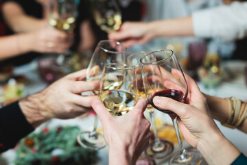 Group of guests celebrate and raise glasses, toasting and cheering with alcohol glasses with wine...