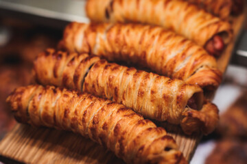 Pastry, selection assortment variety of different bakery, with cinnamon bun, croissant, swiss rolls, cake, eclair and others in a basket or a plate, baked desserts, catering or cafe banquet table