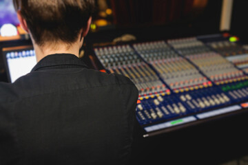 View of lighting technician operator working on mixing console workplace during live event concert...