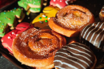 Pastry, selection assortment variety of different bakery, with cinnamon bun, croissant, swiss rolls, cake, eclair and others in a basket or a plate, baked desserts, catering or cafe banquet table