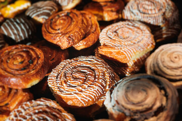 Pastry, selection assortment variety of different bakery, with cinnamon bun, croissant, swiss rolls, cake, eclair and others in a basket or a plate, baked desserts, catering or cafe banquet table