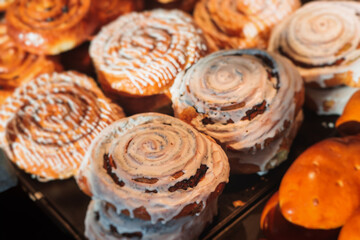 Pastry, selection assortment variety of different bakery, with cinnamon bun, croissant, swiss rolls, cake, eclair and others in a basket or a plate, baked desserts, catering or cafe banquet table