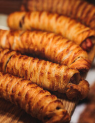 Pastry, selection assortment variety of different bakery, with cinnamon bun, croissant, swiss rolls, cake, eclair and others in a basket or a plate, baked desserts, catering or cafe banquet table