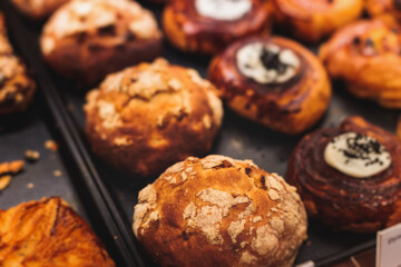 Pastry, selection assortment variety of different bakery, with cinnamon bun, croissant, swiss rolls, cake, eclair and others in a basket or a plate, baked desserts, catering or cafe banquet table
