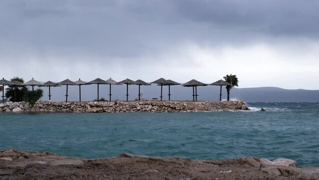 Powerful waves crashing the coast of Njivice, Croatia one day after Storm Ciar&aacute;n smashed into Krk Island. Beautiful rain curtain above the disquiet sea surface. Cinematic water splashes.