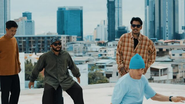 Professional hispanic break dancer practice B boy dance while multicultural friends at roof top. Young modern dancing group doing hip hop movement. Style,fashion,action. Outdoor sport 2024. hiphop.