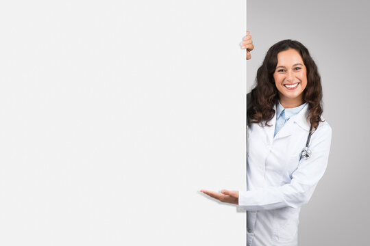 Doctor woman presenting behind blank white board