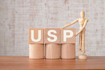 There is wood cube with the word USP. It is an abbreviation for Unique Selling Proposition as...