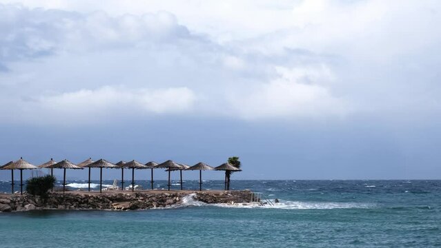 Powerful waves crashing the coast of Njivice, Croatia one day after Storm Ciar&aacute;n smashed into Krk Island. Beautiful disquiet blue sea surface on a rainy day. Cinematic water splashes.