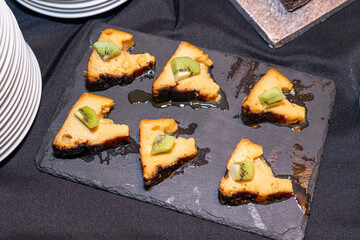 shale stone board with slices of pudding and piece of kiwi