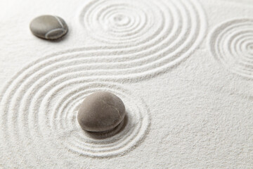 Fototapeta na wymiar Zen garden with the stones and white sand pattern