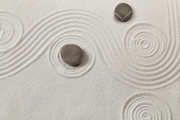 Fototapeta na wymiar Zen garden with the stones and white sand pattern