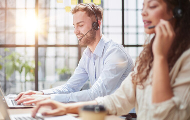 Fototapeta premium male call-center operator with headphones sitting at modern office