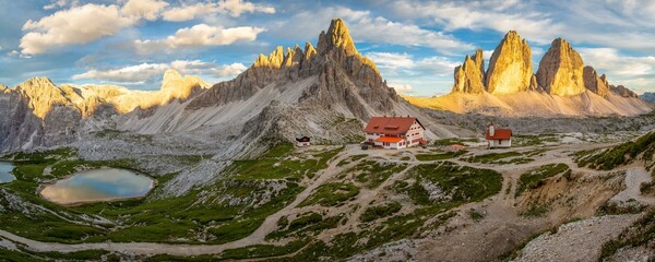View of mountain hut Dreizinnenhuette and chapel with mountain lake rock massif Paternkofel and mountains three peaks in the sunset, panorama, Dolomites, South Tyrol, Italy, Europe