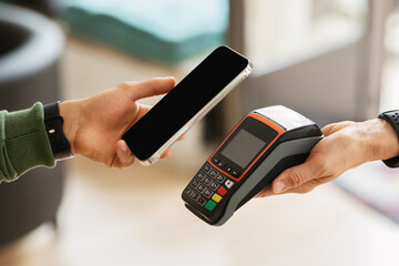 Customer using mobile bank app for payment at cafe