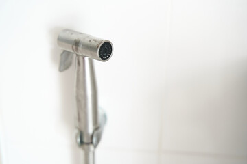 Hygiene concept. New hygienic stall shower head on the white wall background. Intimate hyg.