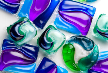Washing capsules, colorful laundry pods. Colorful Soluble capsules with laundry gel detergent and dishwasher soap. Pile of various washing pod capsules. Detergent tablets. Top View, Flat Lay. 