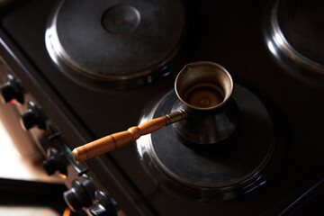 A man preparing black coffee on electric stove. Brew coffee in a Turkish coffee pot