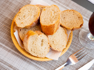 Sliced freshly baked white baguette on plate in restaurant