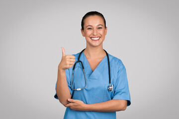 Confident nurse giving thumbs up in scrubs