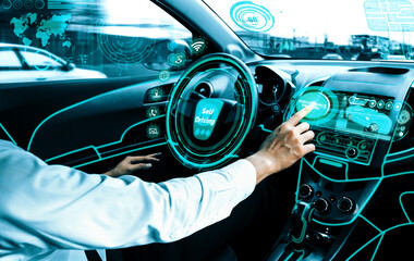 Self-driving autonomous car with relaxed young man sitting at driver seat is driving on busy highway road in the city. Concept of machine learning, artificial intelligence and augmented reality. uds - obrazy, fototapety, plakaty