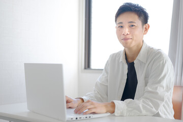 私服でPC作業する爽やかな男性