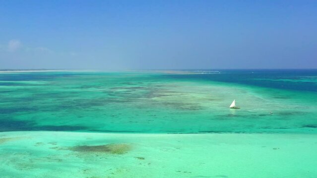 Aerial view of a boat floating on the turquoise water of Indian Ocean.