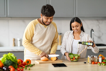 Cute millennial eastern couple preparing healthy dinner together
