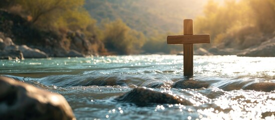 symbol of Baptism a wooden cross in the Jordan River. with copy space image. Place for adding text or design © vxnaghiyev