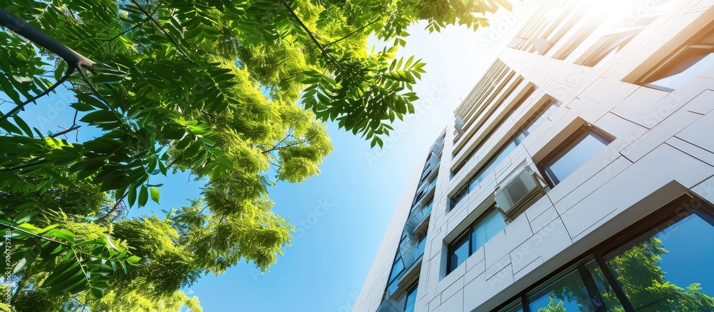 Leinwandbilder tall white building with blue sky and green tree leaves during the day. with copy space image. place