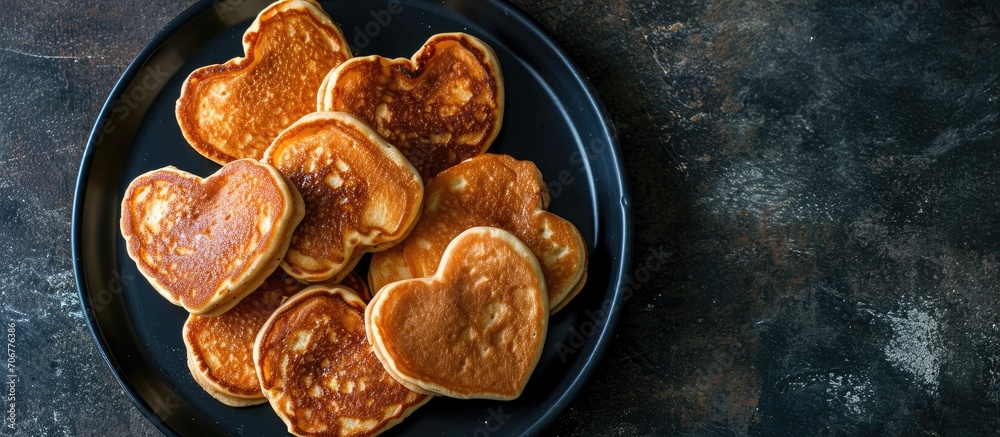 Aufkleber Pancakes in the shape of a heart In a black plate The view from the top. with copy space image. Place for adding text or design