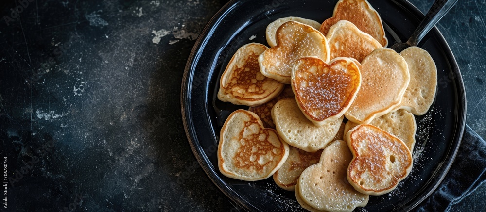 Leinwandbilder Pancakes in the shape of a heart In a black plate The view from the top. with copy space image. Place for adding text or design