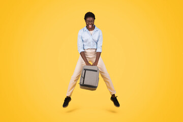 Happy young african american lady student in casual jump with backpack