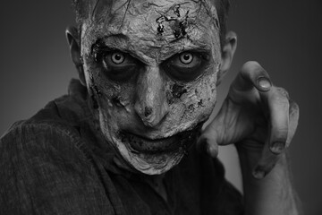 Closeup view of scary zombie on dark background, black and white effect. Halloween monster