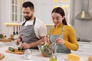 Lovely young couple cooking together in kitchen